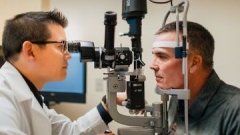 doctor examining patient's eyes through lens