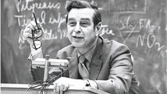 Dr. Ward Perrin at a podium in front of a blackboard.