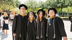 Four graduates posing outside