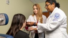 Optometrist and student giving eye exam