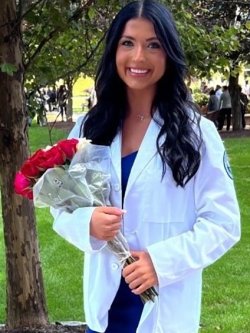 Martina Golaszewski in a white coat photo holding red roses.