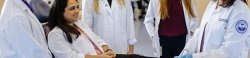 Faculty member showing Podiatry students how to use lab equipment