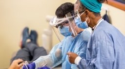 Teacher and student helping a dental patient