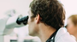 student with microscope.