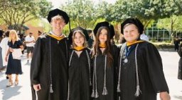 Four graduates posing outside