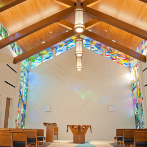 Interior view showing pulpit and stained glass windows.