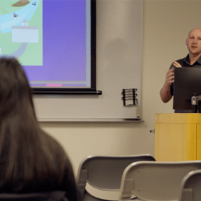 Andrew Hawkeye lectures in a classroom at Midwestern University.