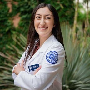 Student in white coat posing for headshot