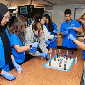 High school students practice mixing medicine.