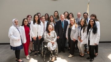 White Coat Students standing in Midwestern Hallway.