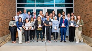 Group photo of researchers standing outside of building.