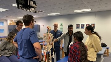 High School Students looking at a skeleton.