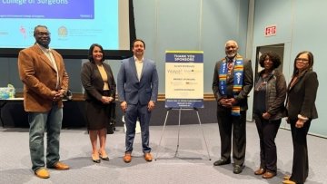 Black men in white coats with Dr. Wooten