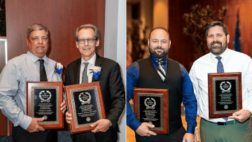 Recipients of the Littlejohn Award display their plaques. 