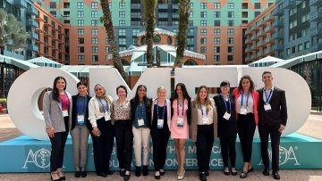 Students attend the OMED conference and gather in front of the OMED sign.