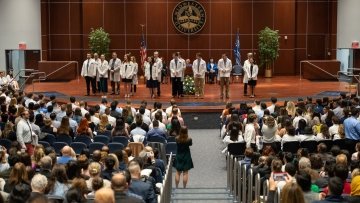 Students receive their white coats.