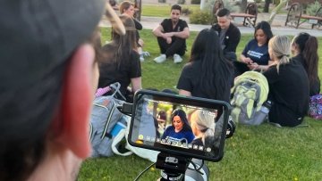 A cameraman for The College Tour takes video of Midwestern University students.