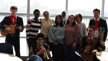 Students and mariachi band take a photo together.