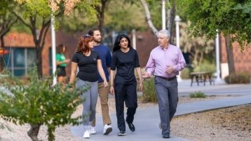Group of 4 people walk outside at the Midwestern University Glendale campus.