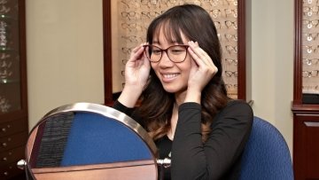 Spring Trunk Show attendee trying on glasses in a mirror.