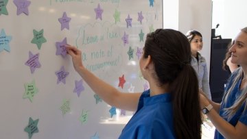 Students add stars to the whiteboard with notes of encouragement.