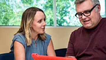 Therapists helps man communicate