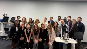 Group of students and vistors pose for photo