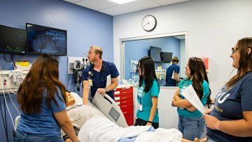A Midwestern student shows undergrad mentees clinical skills in the SIM center