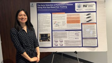 Erin Zou stands in front of research poster