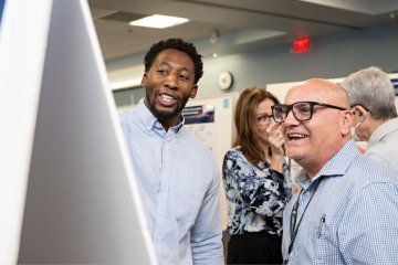 A student explains his research poster 