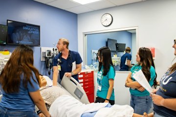 A Midwestern student shows undergrad mentees clinical skills in the SIM center