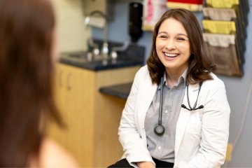 Dr. Kamrie Wolf smiles at a patient in the Student Health Clinic