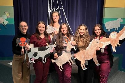 SLP students with Dr. Fissel during the Family Literacy night carrying visual aids to help children read.