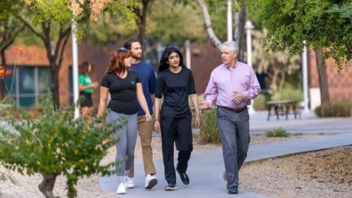 Group of 4 people walk outside at the Midwestern University Glendale campus.