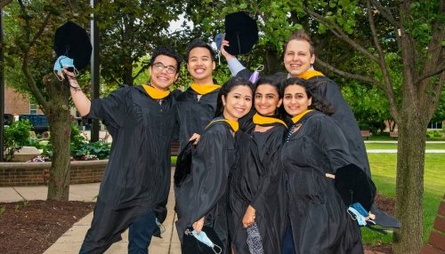 graduates posing outside