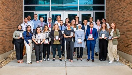 Group photo of researchers standing outside of building.