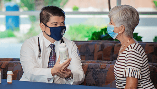 Nursing student meeting with patient to explain medication.