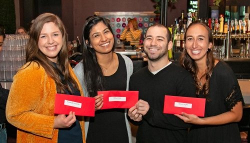 students holding red envelopes