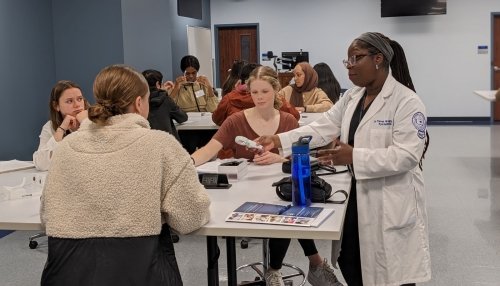 Dr. Parres Wright assists students with optometry lab activities.