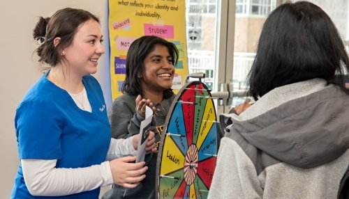 Students spin trivia wheel about Women's History Month.