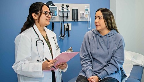 Nurse discussing symptoms with a patient in a checkup room