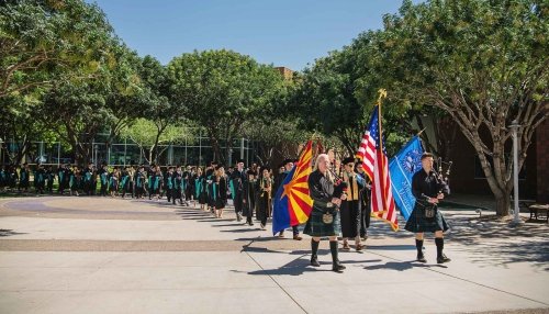 Two bagpipe players lead graduates to their graduation ceremony