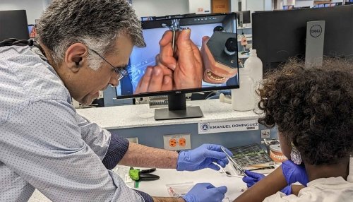 Student learning about dental tools from professor