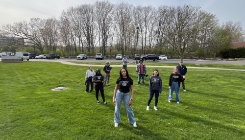 Jordyn Flemons posing in a field with students and camera crew