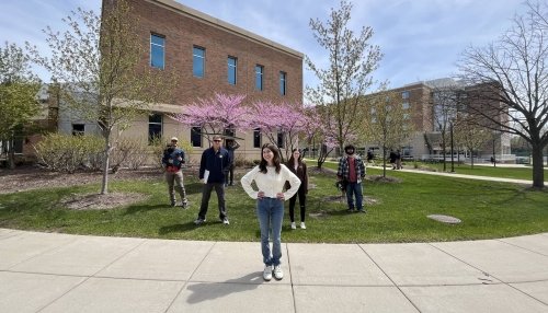 Alexis Flamburis posing with camera crew on Illinois campus