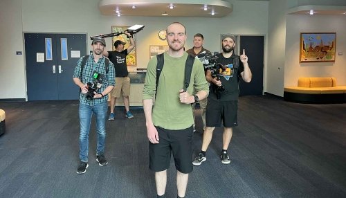 Alex posing with the camera crew of the College Tour.