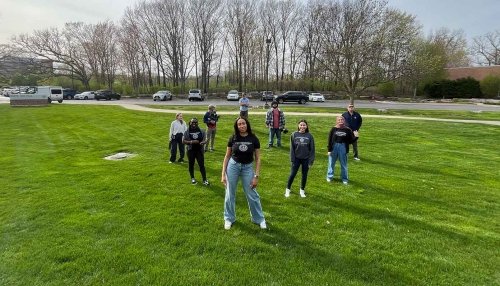 students posing outside on grass