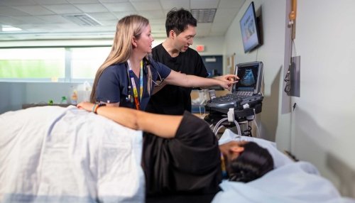 Student performing ultrasound on patient.