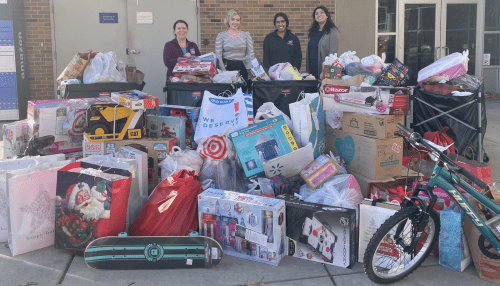 Members of student services in front of holiday donations.