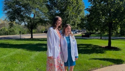 Participating students in their white coats gather for an environmental photo.